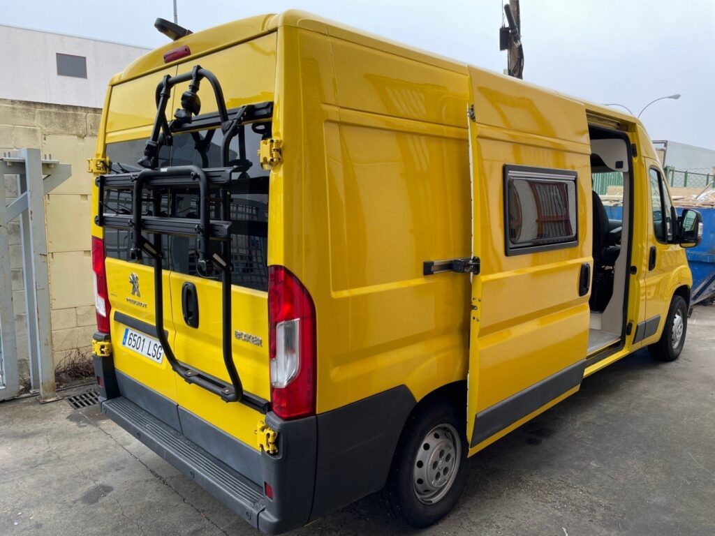 Furgoneta parada: puerta trasera cerrada, soporte para bicicletas, Camperización por Baovan Camper