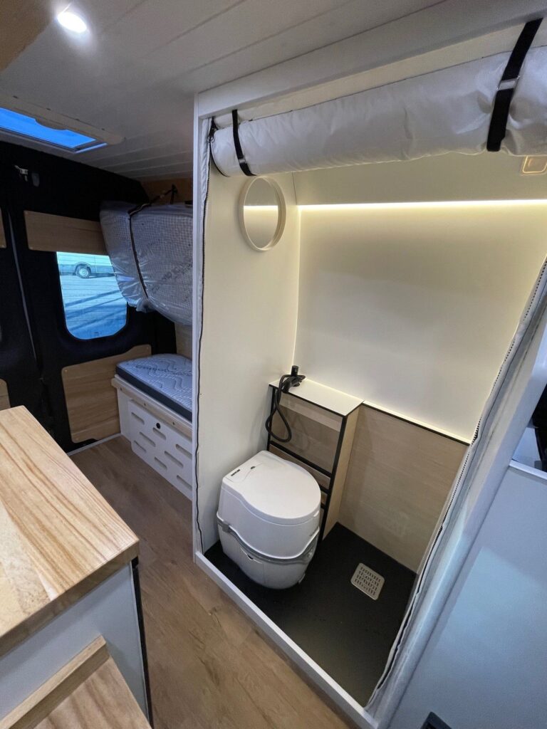 Detalle del baño completo con inodoro y ducha de mano en la Iveco Daily 4+4 Pawlonia. Camperizado por BaovanCamper