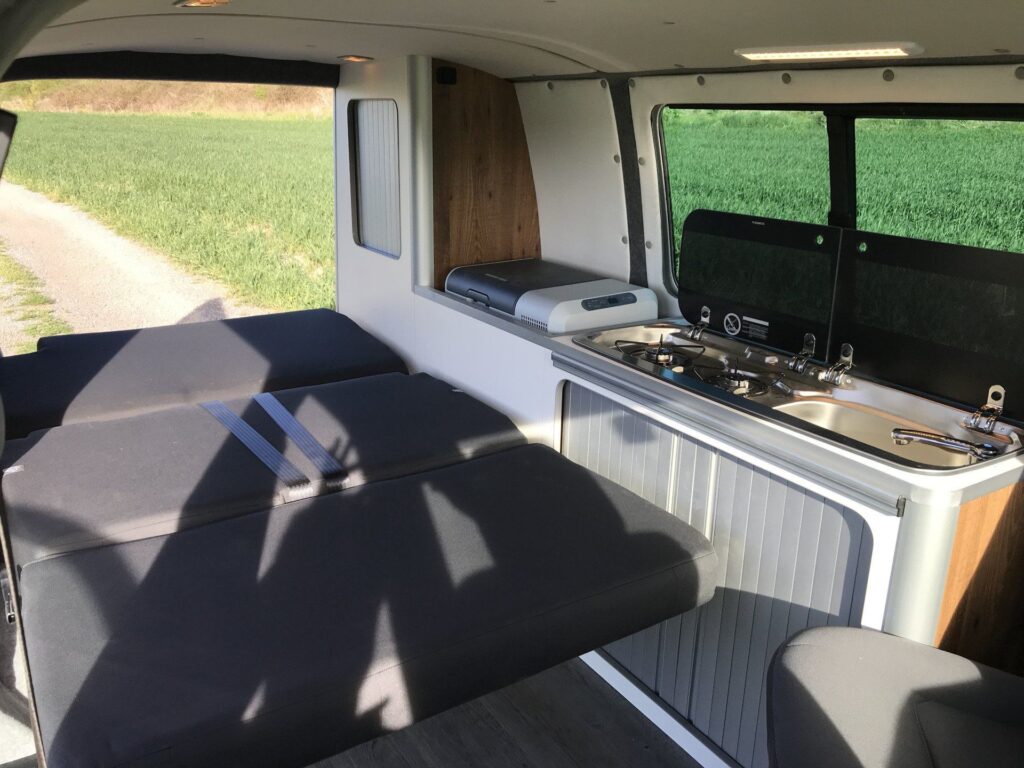 Detalle de la cama abierta vista desde delante, ocupando el interior de la Volkswagen Transporter T5