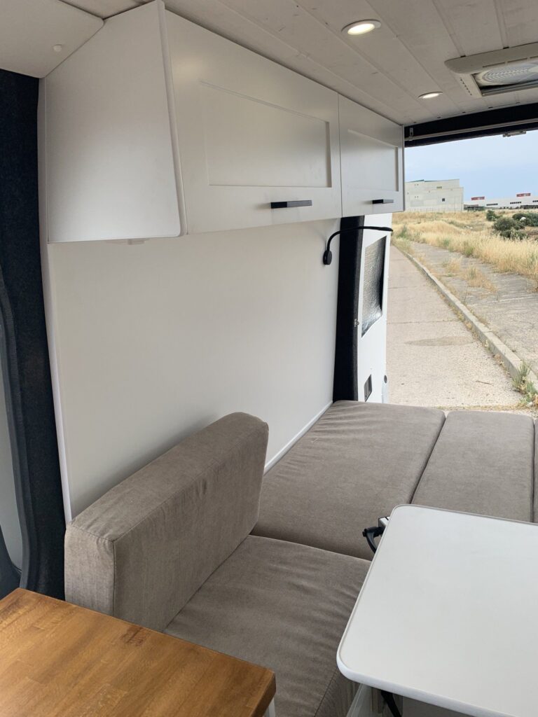 Detalle de la zona de descanso con sofás y armarios suspendidos en la Camper Mercedes Sprinter L3H2 4+4. Camperizado por BaovanCamper.