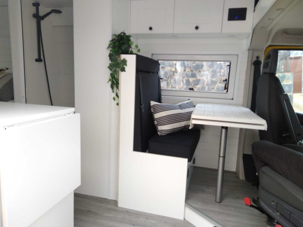Vista lateral de la Peugeot Boxer L3H2 4+2 CORIAN, Camperización por Baovan Camper, con zona de descanso y mesa extensible.
