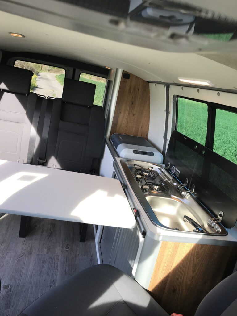 Detalle de la zona de cocina: fregadero frente a una ventana en la Volkswagen Transporter T5