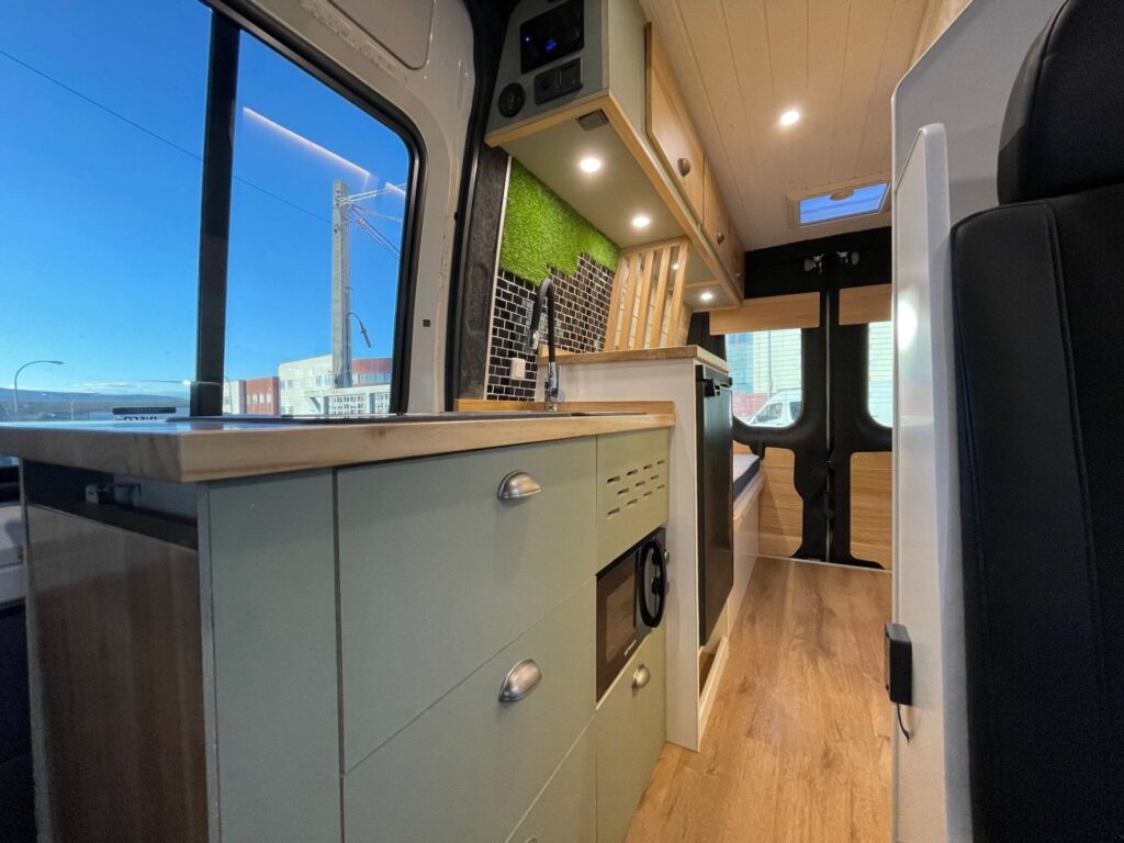 Detalle de la cocina: gran ventana, mucho espacio de almacenamiento, horno microondas. Camperizado por BaovanCamper