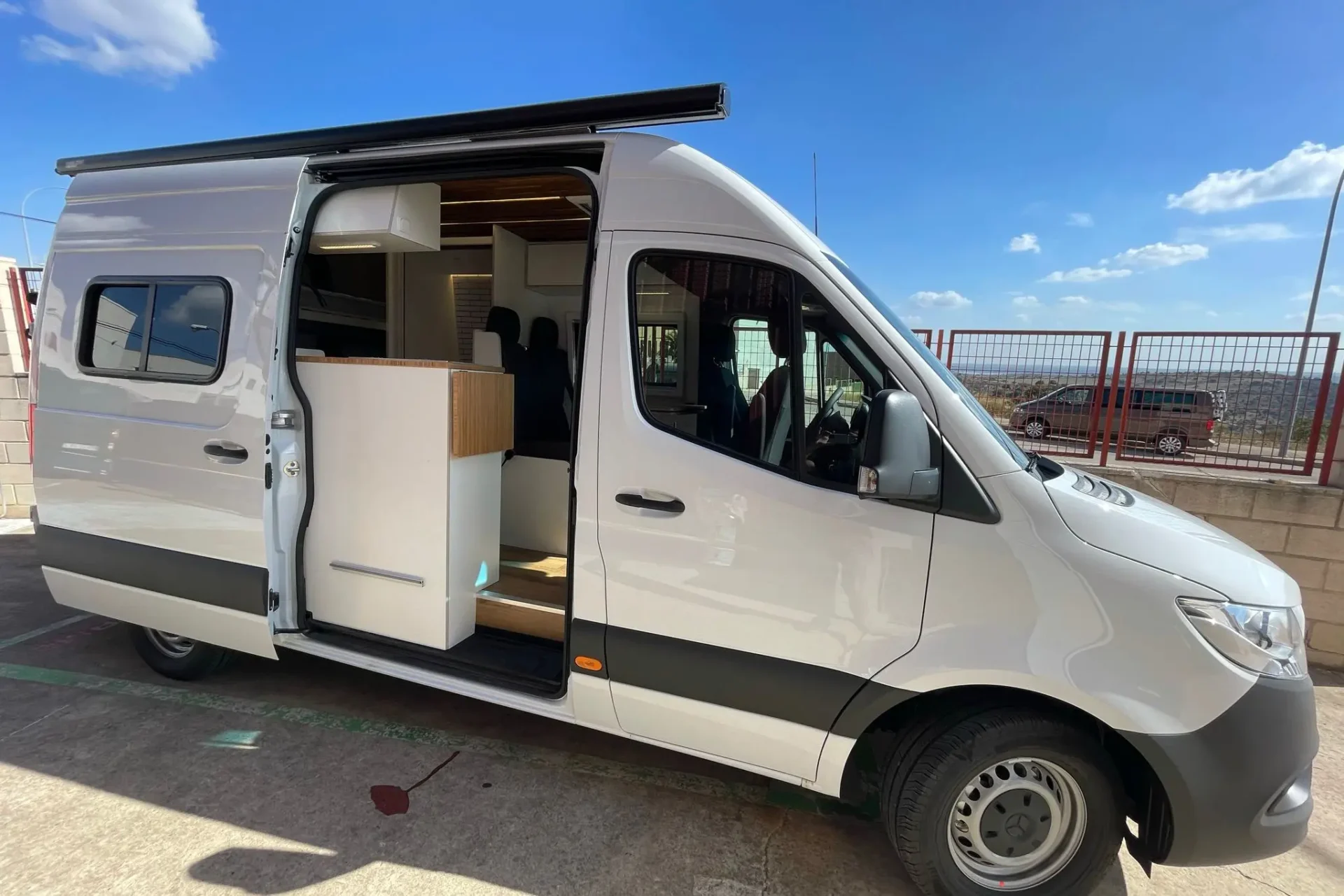 Mercedes-Benz Sprinter 4x4 camperizado con estilo, mostrando su interior personalizado con puertas abiertas