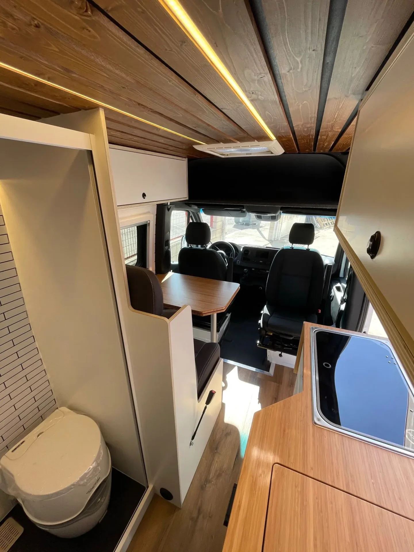 MB Sprinter Camper 4+4 Con Estilo con baño completo, espacio para cocinar y mesa plegable.