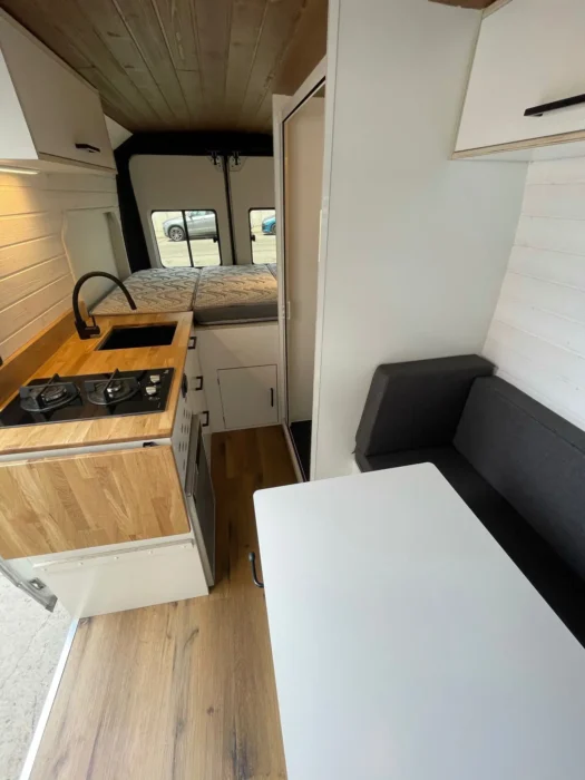 Perspectiva del área de salón y cocina en la Camper L3H2, enfatizando la comodidad y el diseño inteligente del espacio habitable.