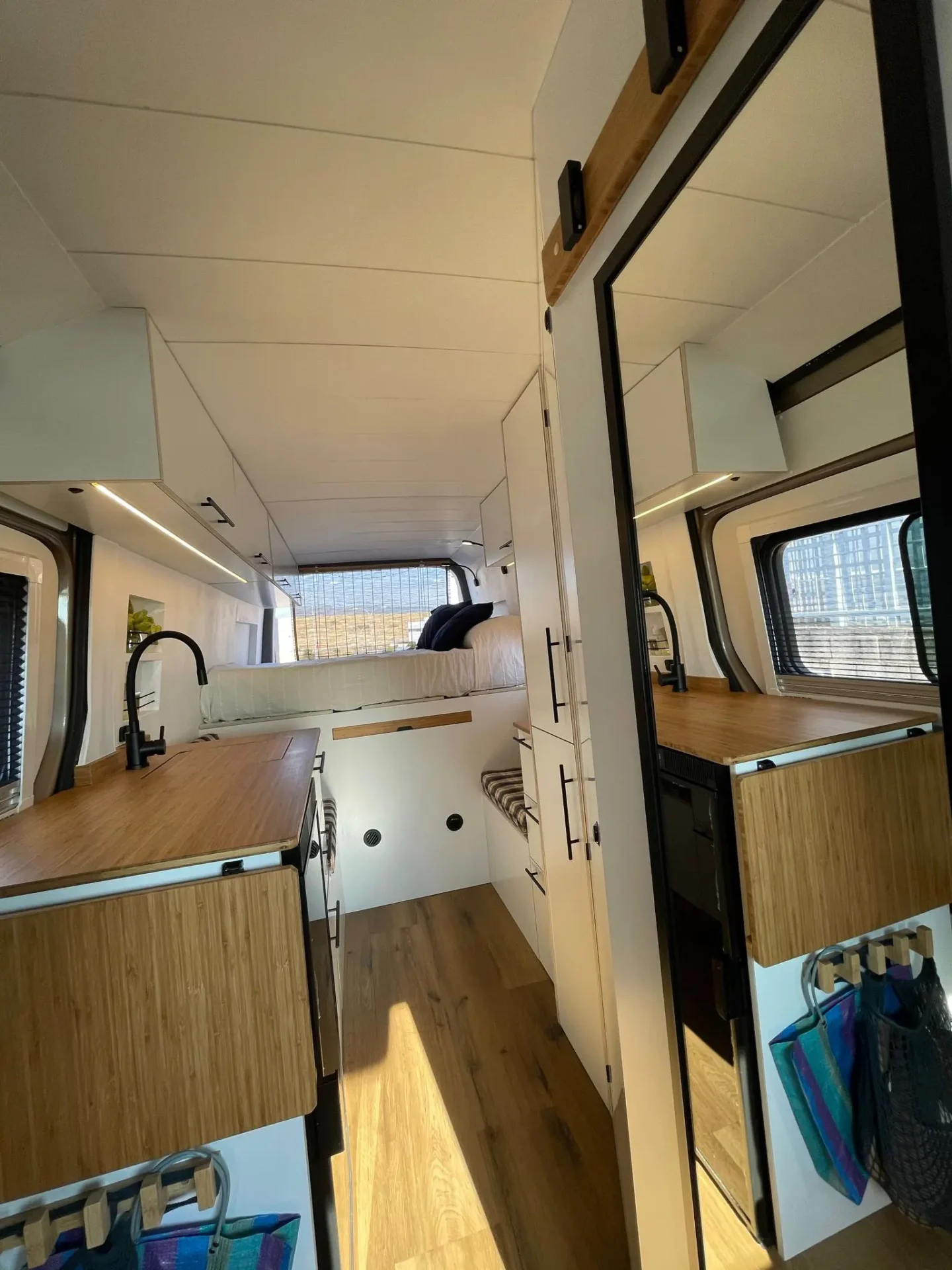 Camper VW Crafter L4H2 con amplio espacio de almacenamiento, espejo, fregadero y encimera extensible.