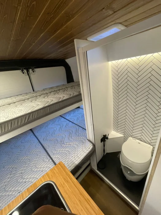 Peugeot Boxer Camper con camas tipo litera para 4 personas, ilustrando el uso eficiente del espacio y el diseño práctico.