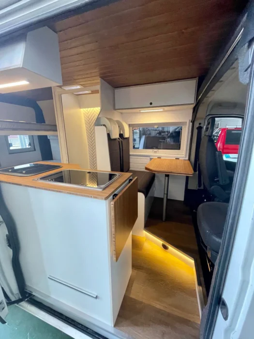 Vista desde la puerta de entrada de la Peugeot Boxer Camper, invitando a entrar a un espacio habitable bien equipado y listo para viajar.