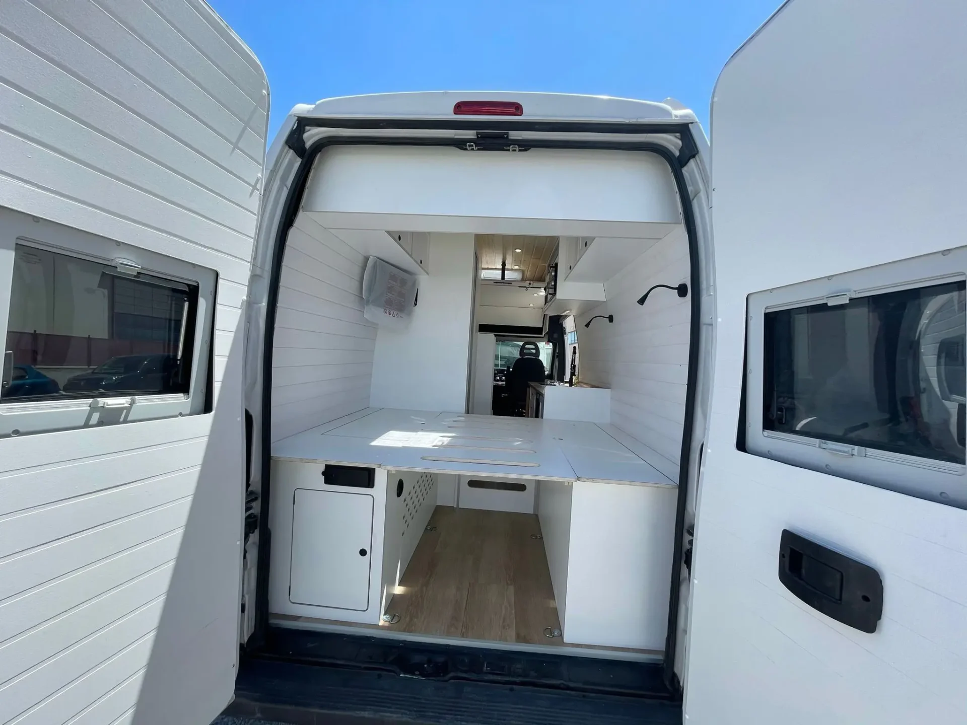 Perspectiva desde la parte trasera de la furgoneta camper Ducato L4H3, destacando la distribución interna y el acceso a la cocina y el área de descanso.