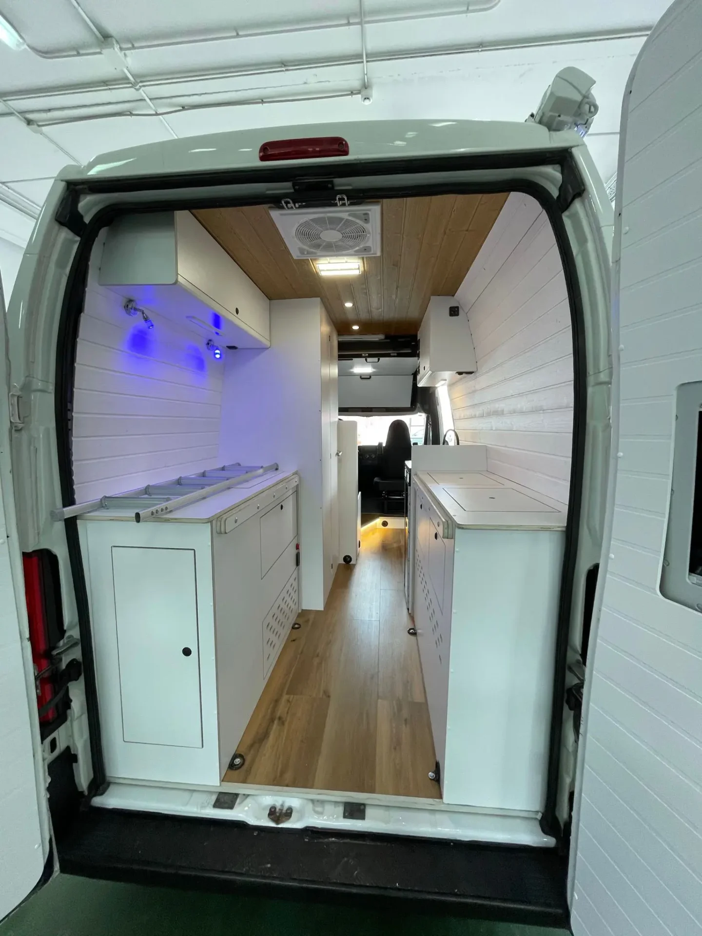 Fiat Ducato L3H3 con amplio espacio interior en blanco, gran cantidad de armarios y puerta trasera abierta mostrando la extensión completa.