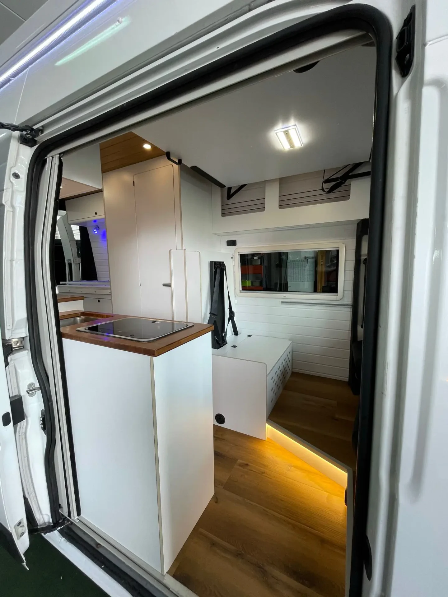 Fiat Ducato L3H3 con detalle del fregadero y las sillas con acabado blanco y clásico.
