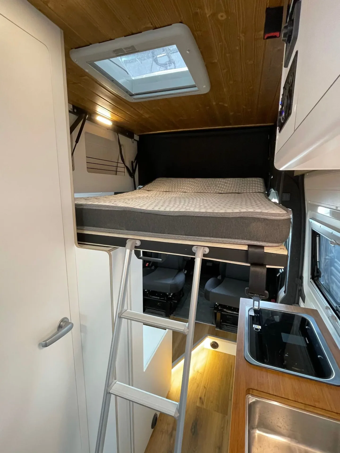 Fiat Ducato L3H3 con cama abatible sobre las sillas de la cabina, espacio adicional para dormir.