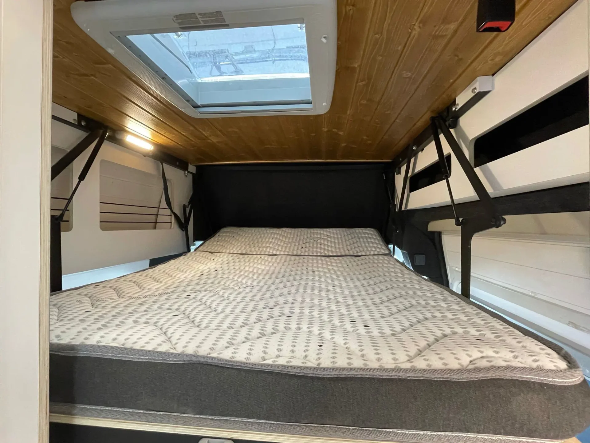Fiat Ducato L3H3 con detalle de la cama plegable abierta, comodidad y espacio.