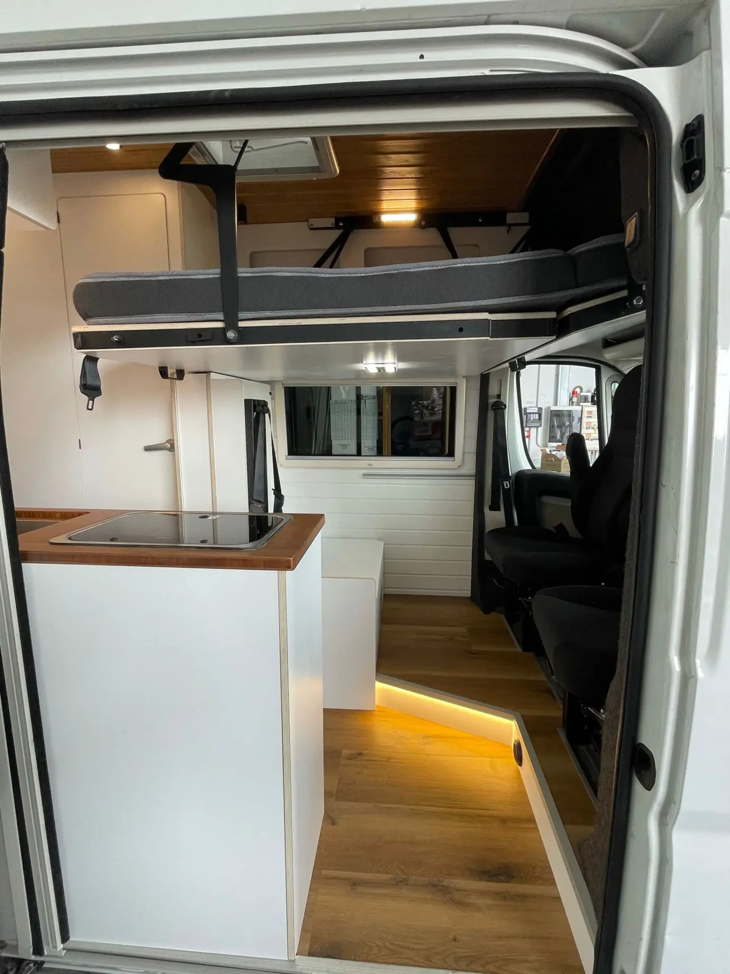 Vista lateral de la Fiat Ducato L3H3 con cama plegable abierta, diseño y confort.