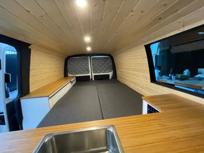 Detalles de la cama extendida de la VW T6 Camper vista desde la parte delantera de la furgoneta.