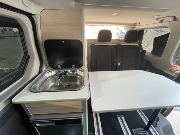 Renault Trafic Camper con espacio de descanso abierto: fregadero, mesa y espacio para sentarse.