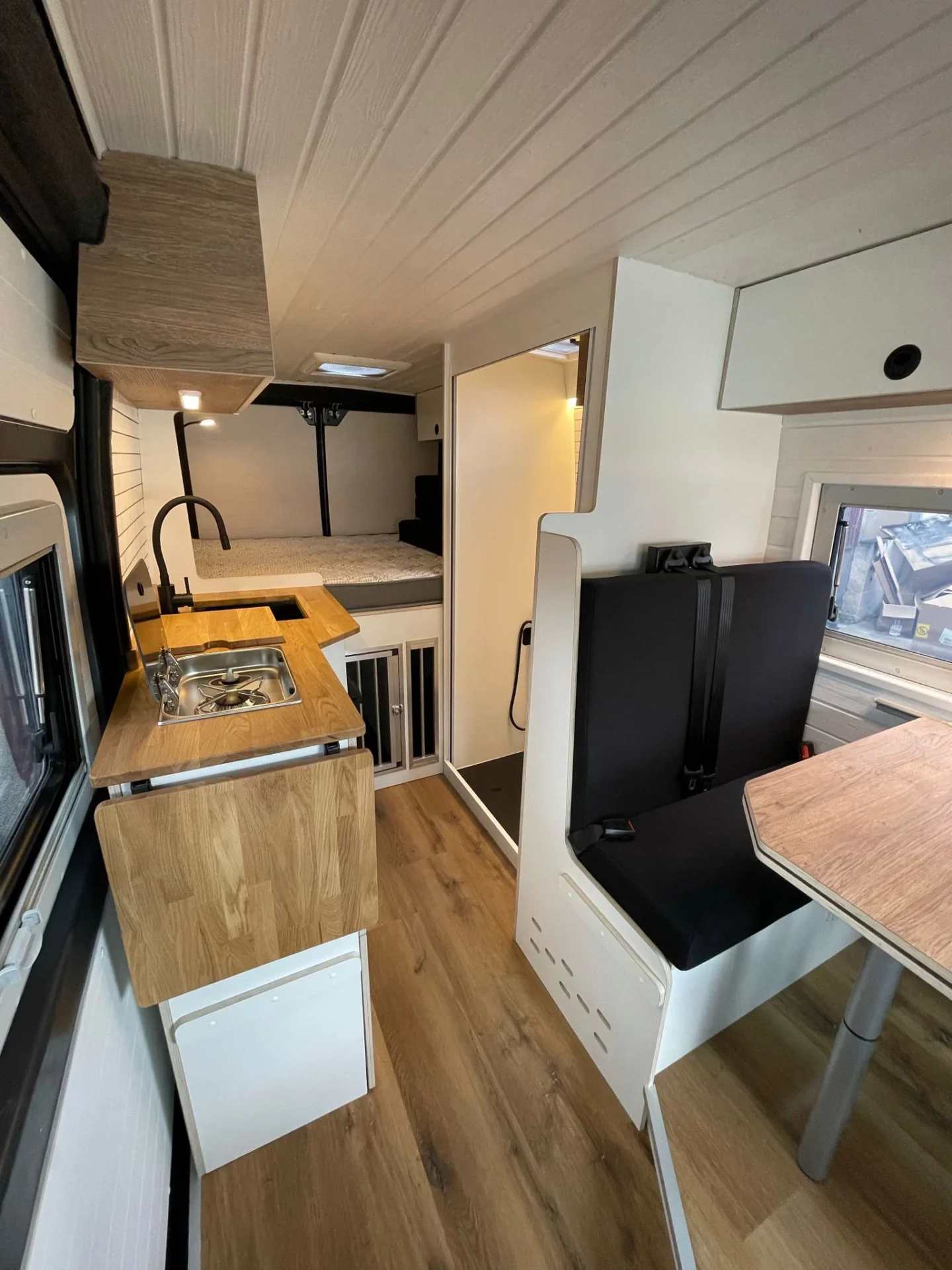 Mesa, área de cocina, baño abierto con ducha completa y cama