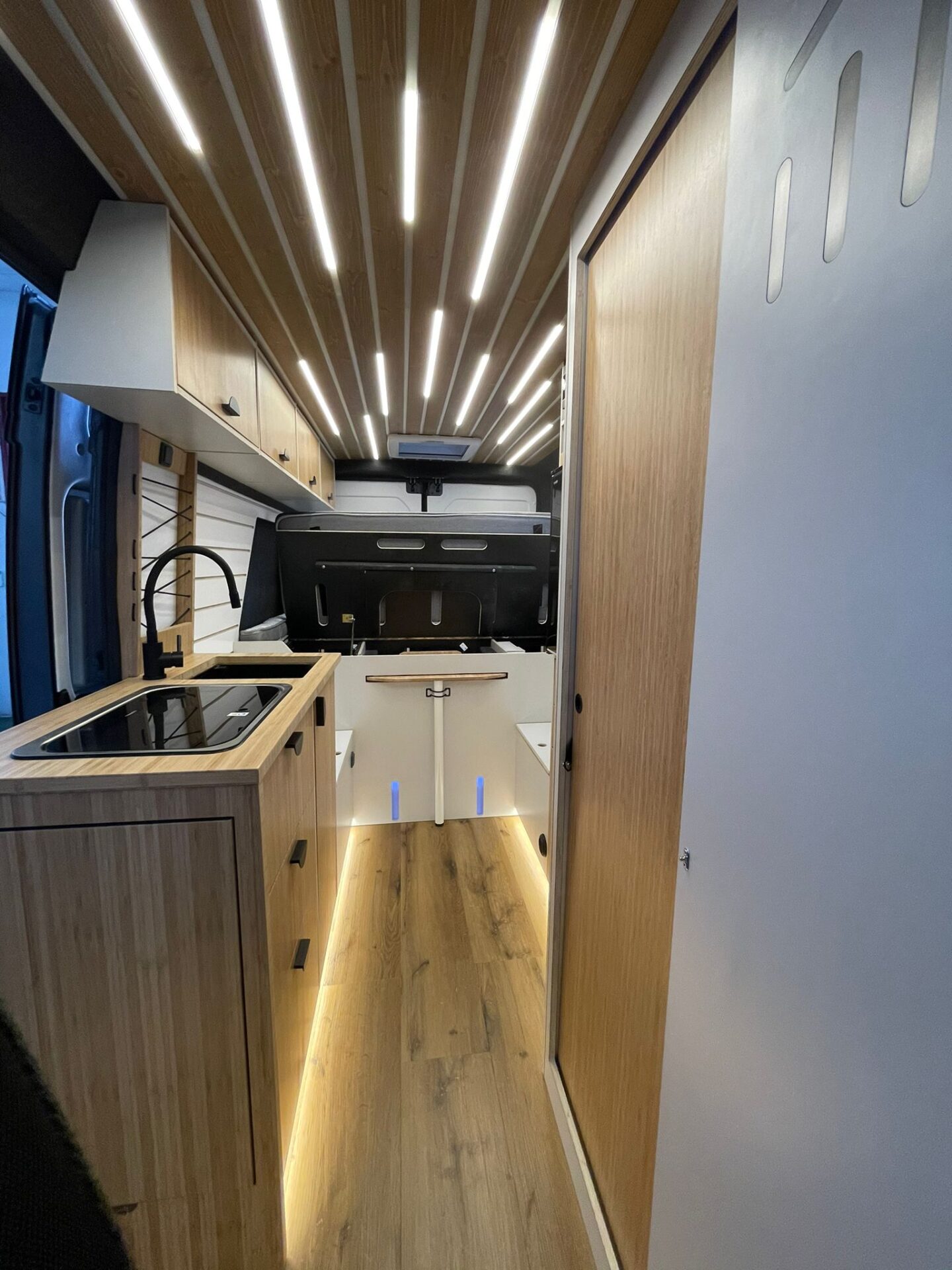 Espacio de cocina con cama plegada, mostrando espacio de almacenamiento debajo