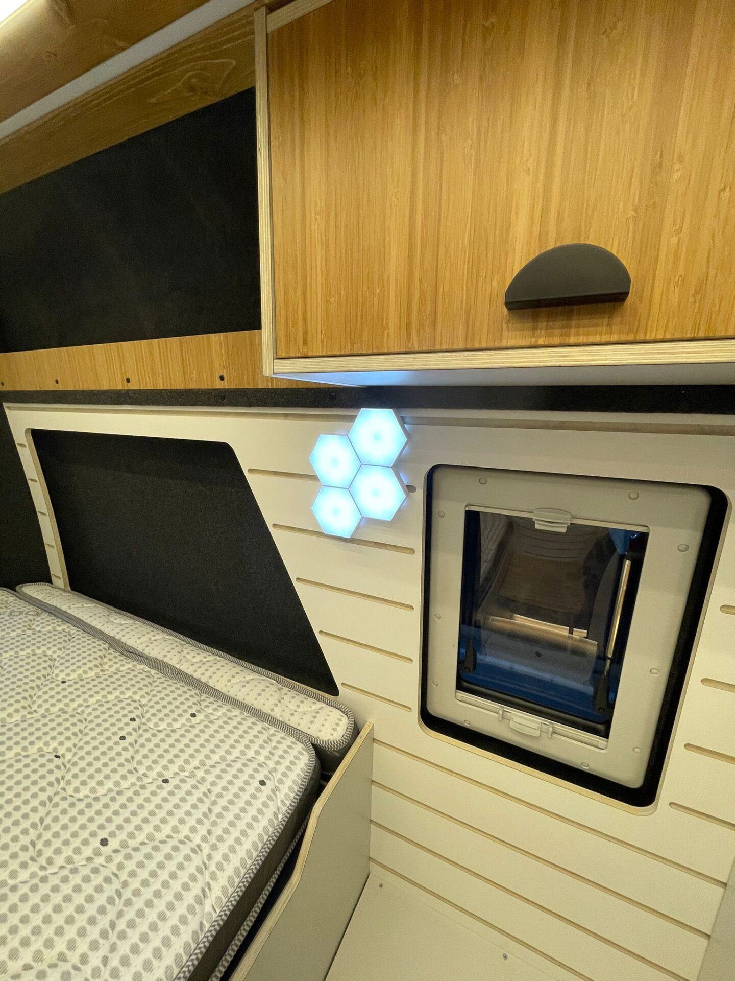 Cama con iluminación moderna, con detalle de ventana