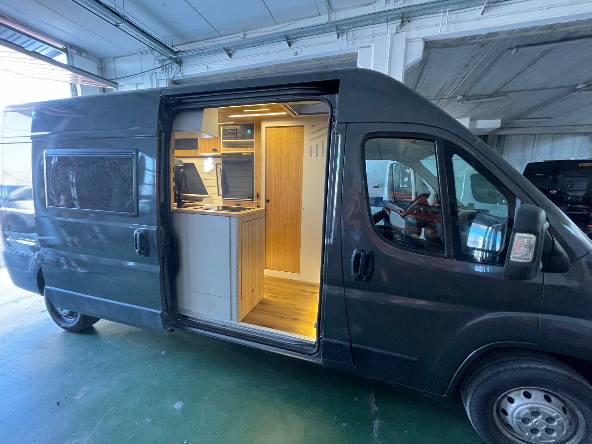 Camper Baovan con puerta corredera abierta ofreciendo una vista del interior bien iluminado con acabados de madera.